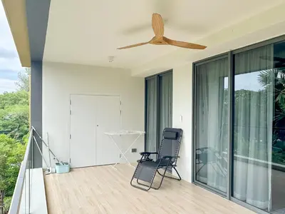 a chair on a balcony with a ceiling fan at Laguna BeachSide Apartment in Bang Tao Beach