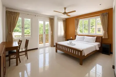 a bedroom with a bed and a desk and windows at Payton House Patong - Newly Renovated in Patong Beach