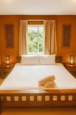 a bedroom with a large bed with a window at Payton House Patong - Newly Renovated in Patong Beach