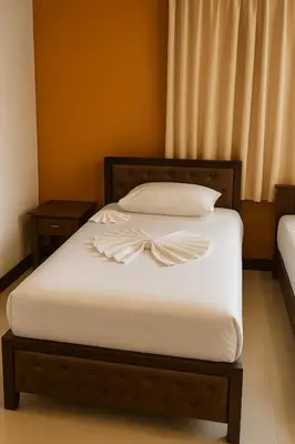 a bed with white sheets and a bow on it at Payton House Patong - Newly Renovated in Patong Beach