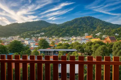 a view of a city from behind a wooden bench at Payton House Patong - Newly Renovated in Patong Beach