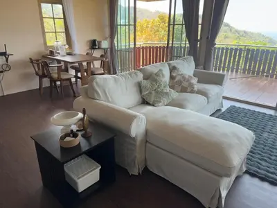 a living room with a white couch and a table at Choncharm house 2 in Kata Beach