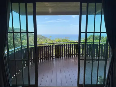 a view from a window of a deck with the ocean at Choncharm house 2 in Kata Beach