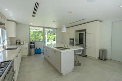 a large kitchen with white cabinets and a large island at Top Pool Villa Layan Estate Laguna Bangtao in Layan Beach