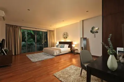 a bedroom with a bed and a table and a desk at Coconut villa Phuket in Laguna Phuket