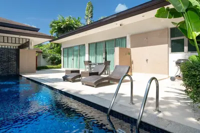 a house with a swimming pool next to a house at Coconut villa Phuket in Laguna Phuket