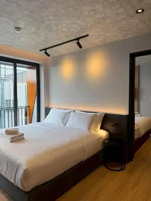 a bedroom with a large white bed and a window at Lush inn Phuket in Ban Suan