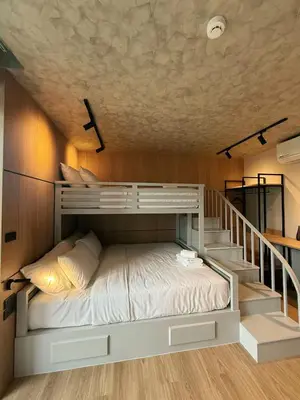 a bunk bed in a room with a staircase at Lush inn Phuket in Ban Suan