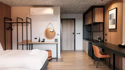 a hotel room with a bed and a desk at Lush inn Phuket in Ban Suan