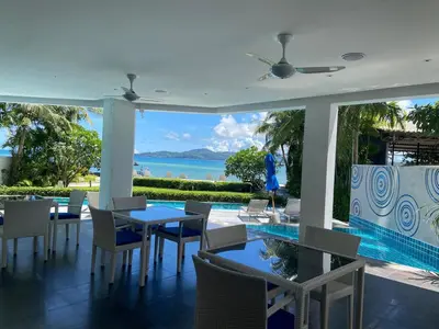 a dining room with a view of the ocean at Luxuriously private seafront Bangtao beach in Surin Beach