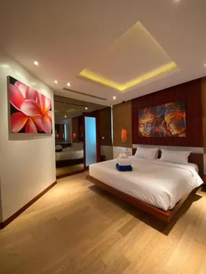 a bedroom with a large bed and a painting on the wall at Luxuriously private seafront Bangtao beach in Surin Beach