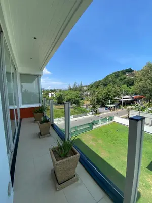 a balcony of a house with a view of a yard at Luxuriously private seafront Bangtao beach in Surin Beach