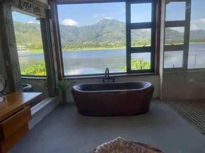 a bathroom with a large tub in front of a window at Tranquil lake view villa on Phuket golf estate in Kathu