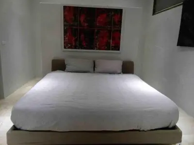 a large white bed in a room with a painting at Tranquil lake view villa on Phuket golf estate in Kathu