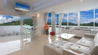 a living room with a white couch and a table at PATONG TOWER FAMILY's APARTMENTS 2026 in Patong Beach