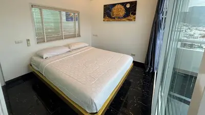 a small bedroom with a bed and a window at PATONG TOWER FAMILY's APARTMENTS 2026 in Patong Beach