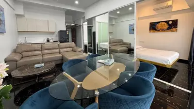 a living room with a glass table and blue chairs at PATONG TOWER FAMILY's APARTMENTS 2026 in Patong Beach