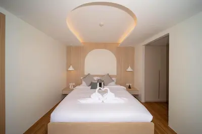 a bedroom with a large white bed with an arched window at \u5168\u65b0\u73b0\u4ee3\u98ce\u683c \u9b45\u529b\u6cf3\u6c60\u516c\u5bd3 in Kamala Beach