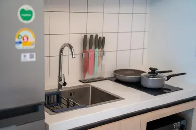 a kitchen with a sink and a stove with utensils at \u5168\u65b0\u73b0\u4ee3\u98ce\u683c \u9b45\u529b\u6cf3\u6c60\u516c\u5bd3 in Kamala Beach
