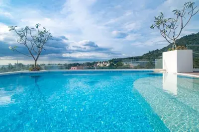 a large swimming pool with blue water at \u5168\u65b0\u73b0\u4ee3\u98ce\u683c \u9b45\u529b\u6cf3\u6c60\u516c\u5bd3 in Kamala Beach