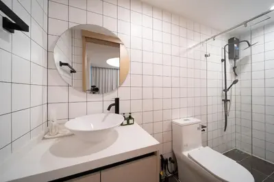 a white bathroom with a sink and a mirror at \u5168\u65b0\u73b0\u4ee3\u98ce\u683c \u9b45\u529b\u6cf3\u6c60\u516c\u5bd3 in Kamala Beach
