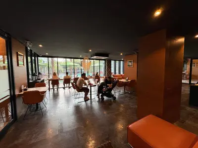 a group of people sitting at tables in a restaurant at Citygate Kamala beach, luxury apartment, Phuket in Kamala Beach