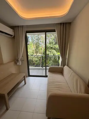a living room with a couch and a large window at 1 bedroom in Kamala Beach in Kamala Beach