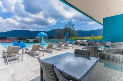 a patio with chairs and a swimming pool at Studio Sea view with kitchen by Renttini in Kamala Beach