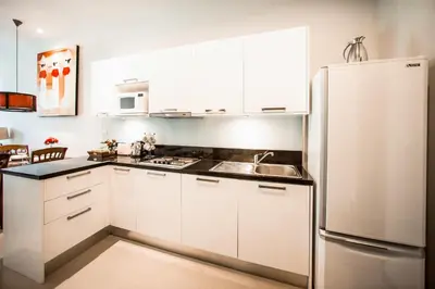 a kitchen with white cabinets and a refrigerator at VILLA Emere Private Pool Nai Harn beach in Nai Harn Beach