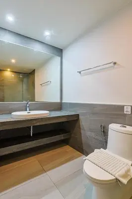 a bathroom with a sink and a toilet and a mirror at Pool View 1 Bed Apt T2-520 in Chalong