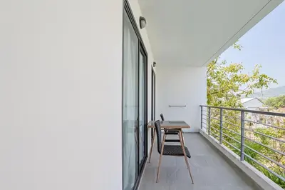 a balcony with a table and a chair on it at Pool View 1 Bed Apt T2-520 in Chalong