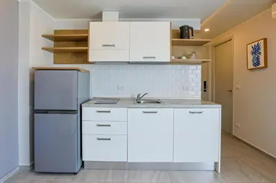 a kitchen with white cabinets and a refrigerator at Mountain View 1 Bed Apt T2-723 in Chalong