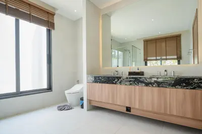 a bathroom with a sink and a toilet and a mirror at Mouana Breeze Mai Khao 5-bedroom Pool Villa 9914 in Mai Khao Beach