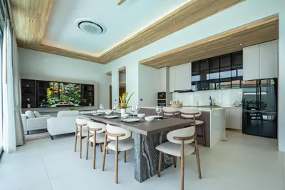 a kitchen and dining room with a large wooden table and chairs at Mouana Breeze Mai Khao 5-bedroom Pool Villa 9914 in Mai Khao Beach