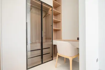 a room with a desk and a chair next to a closet at Mouana Breeze Mai Khao 5-bedroom Pool Villa 9914 in Mai Khao Beach