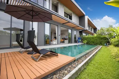 a pool with a chair and an umbrella next to a house at Chalong Bay View 3BR Pool Villa Long One A4 in Chalong