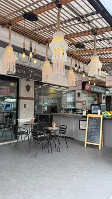 a restaurant with tables and chairs and chandeliers at Cocoon Talya Hotel in Patong Beach