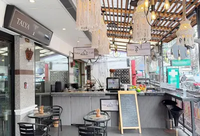 a restaurant with tables and chairs and chandeliers at Cocoon Talya Hotel in Patong Beach
