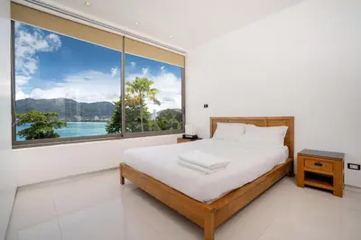 a bedroom with a bed and a large window at Atika Villas xero oceanfront pool villa in Patong Beach