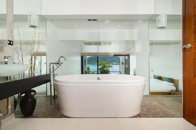 a large white tub in a bathroom with a sink at Atika Villas xero oceanfront pool villa in Patong Beach