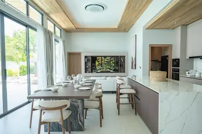 a dining room with a table and chairs in a kitchen at Mouana Breeze Mai Khao VIP 4-bedroom Pool Villa 9913 in Mai Khao Beach