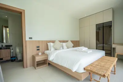 a bedroom with a large bed and a large mirror at Mouana Breeze Mai Khao VIP 4-bedroom Pool Villa 9913 in Mai Khao Beach