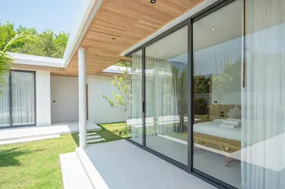 an internal view of a house with glass walls at Mouana Breeze Mai Khao VIP 4-bedroom Pool Villa 9913 in Mai Khao Beach