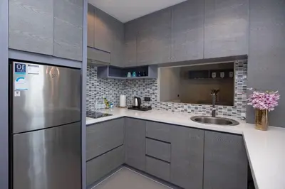 a kitchen with gray cabinets and a stainless steel refrigerator at Citygate 2BR Suite CTG L402-3, Top Facilities, near FantaSea & Café Del Mar Beach Club in Kamala Beach