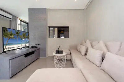 a living room with a white couch and a flat screen tv at Tropics & Modern Stay - Kamala 2BR Suite CTG L502-3, Best Amenities & Beach Fun in Kamala Beach