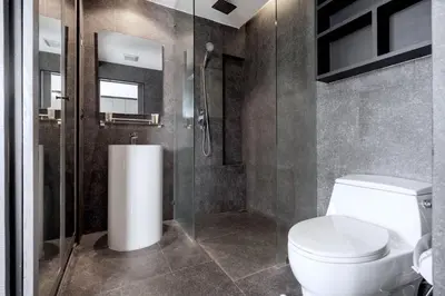 a bathroom with a toilet and a glass shower at Tropics & Modern Stay - Kamala 2BR Suite CTG L502-3, Best Amenities & Beach Fun in Kamala Beach