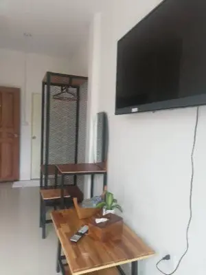 a living room with a table and a flat screen tv at Katika Home 2 in Ban Khlong Haeng