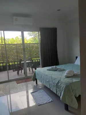 a bedroom with a bed and a view of a balcony at Katika Home 2 in Ban Khlong Haeng