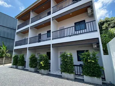 a white building with plants in front of it at Guest Room Bang Tao MMA in Ban Thalat Choeng Thale
