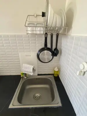a kitchen sink with utensils on a wall at Guest Room Bang Tao MMA in Ban Thalat Choeng Thale